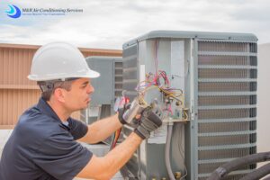 worker repairing air conditioning unit